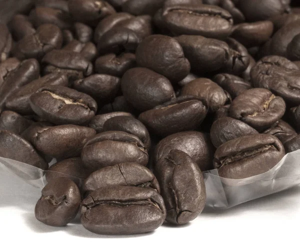 Крупним планом кавові зерна з фокусом на одному Ліцензійні Стокові Зображення