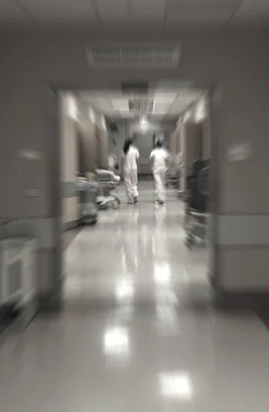 Médicos y enfermeras caminando en el pasillo del hospital, movimiento borroso . —  Fotos de Stock