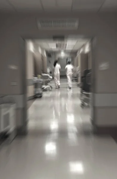 Лікарі та медсестри, що ходять у лікарняному коридорі, розмиті рухи . Стокове Зображення