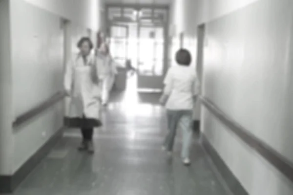 Doctors and nurses walking in hospital hallway, blurred motion. Royalty Free Stock Images