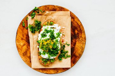 Kızarmış yumurta ve ahşap kesme tahtasındaki taze otlar.