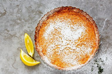 Ev yapımı limonlu turta üzerine krema serpiştirilmiş şeker serpilmiş.