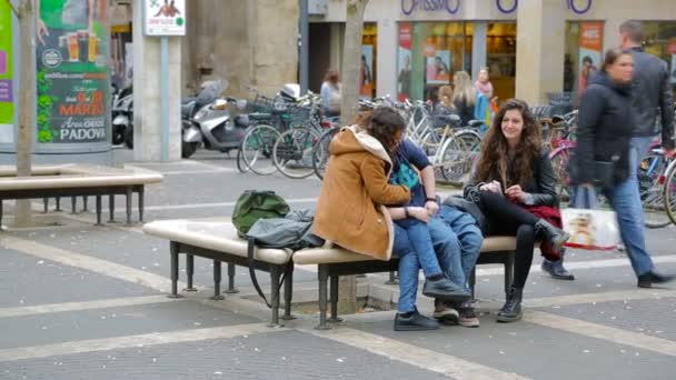 Junge Studentin albert herum und lacht, während sie auf einer Bank sitzt — Stockvideo