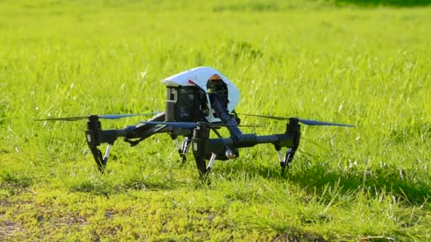 Drone lyfter med grönt gräs upp, består chassi och flyger fram — Stockvideo