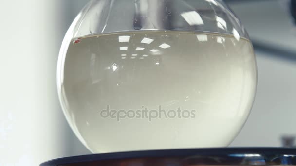 Líquido ligero está burbujeando en un frasco — Vídeos de Stock
