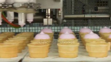 Dondurma Fabrikası. Dondurma ile gofret bardak doldurma. Pembe meyveli ve vanilyalı dondurma waffle Kupası'nda. Otomatik dondurma imalatı.