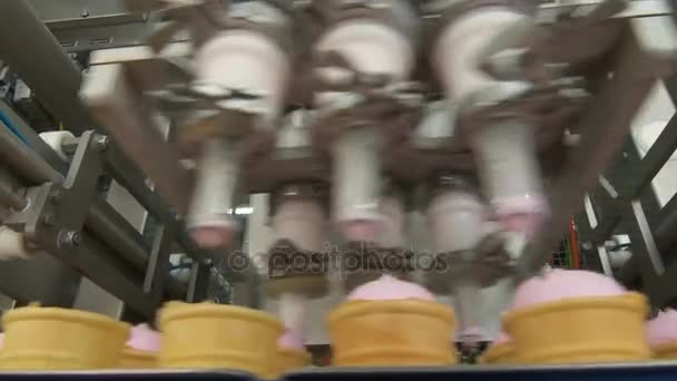 アイスクリーム工場 アイスクリームのウェーハ カップの充填 ピンクのフルーティー バニラ アイス クリーム ワッフル カップに アイスクリームの自動化生産 — ストック動画