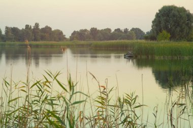 Avcıların tüfeklerle gölde tekne avı ördek