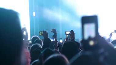 Festivaldeki konserin fotoğrafını ve videosunu çeken bir hayran..