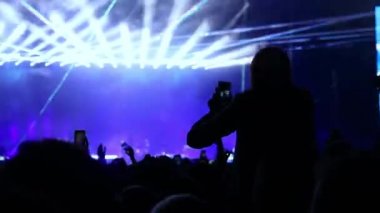 Konserdeki kız ellerini kaldırıp dans ediyor.