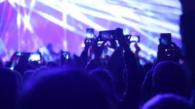 Festivaldeki konserin fotoğrafını ve videosunu çeken bir hayran..