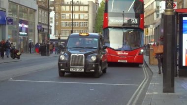 Londra otobüs durağından çift katlı kırmızı otobüs kalkıyor.