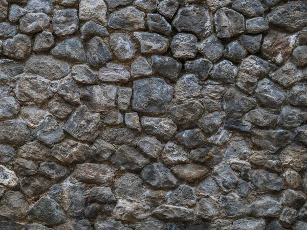 Steinmauer aus dunklem Kopfsteinpflaster. — Stockfoto