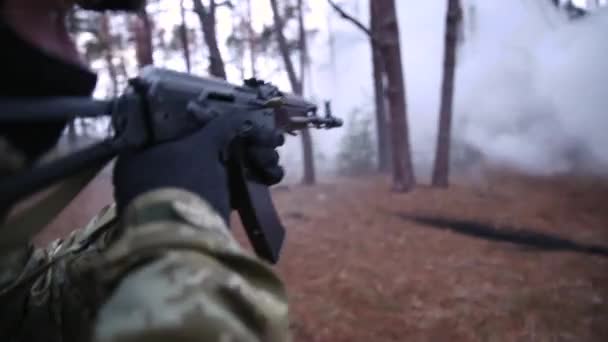 Soldado con un arma se mueve a través de un bosque humeante — Vídeo de stock