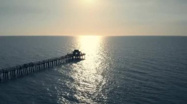 Sunset over ocean or sea, Drone flying above pier