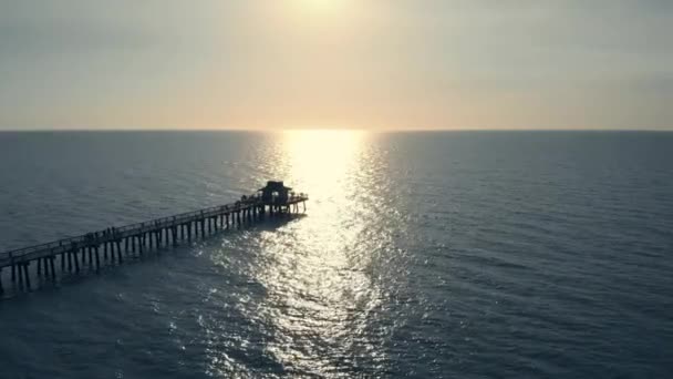 Coucher de soleil sur l'océan ou la mer, Drone volant au-dessus de la jetée — Video