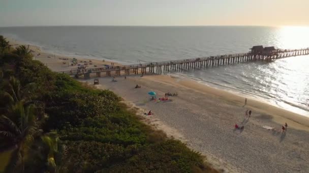 Costa e praia perto do cais saindo para o oceano — Vídeo de Stock