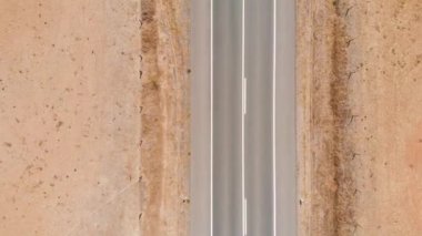 Top view drone, zoom out above narrow desert road