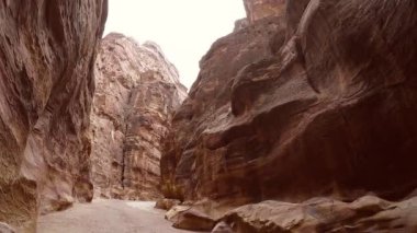 Petra şehrindeki Al Siq Kanyonu 'nun içinde yürüyorum.