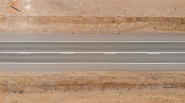 Dar çöl yolunun üstünde insansız hava aracı görüntüsü.