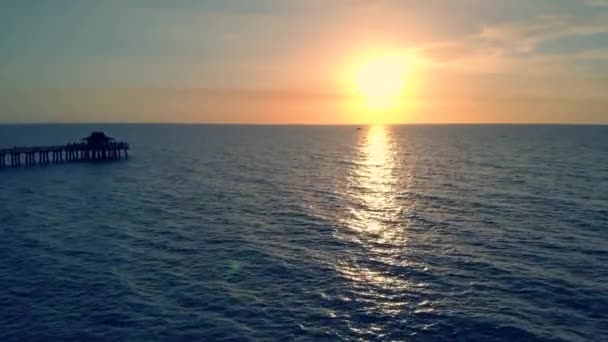 Silueta de un muelle sobre el agua al atardecer, 4k — Vídeo de stock