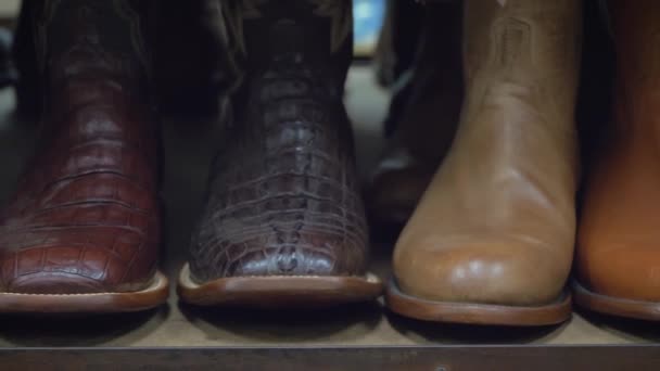 Botas de vaquero en un estante en la tienda alineadas, primer plano . — Vídeos de Stock