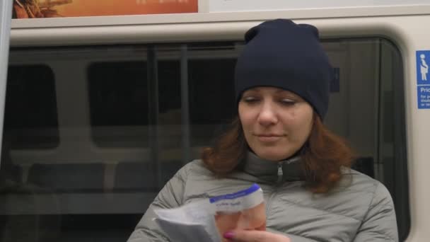 Meisje reist in de metro en kijkt in papieren kaart — Stockvideo