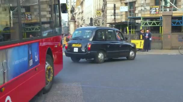 Отслеживание черных такси и красного автобуса на улице Лондона — стоковое видео
