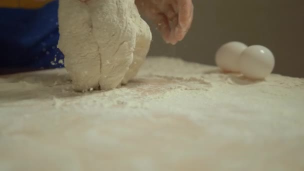 男性の手はテーブルの上に小麦粉で生地をこねる.4k — ストック動画