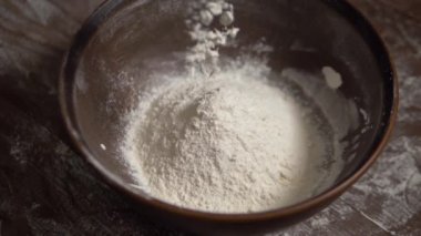 Un ağır çekimde kahverengi bir kaseye düşer.