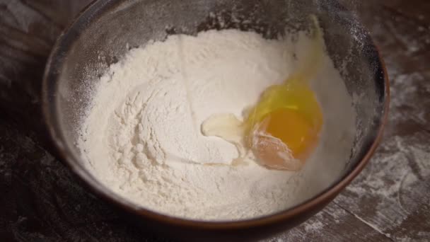 Медленный выстрел яйца падает на миску с мукой . — стоковое видео