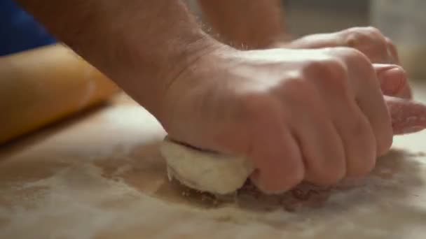 Male hands kneading dough in flour on table. — 비디오