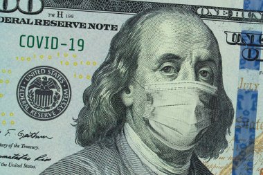 100 dolarlık banknotta tıbbi maske, küresel ekonomik kriz kavramı. Amerikan parasında tıbbi maske ya da cerrahi maske. ABD 'de COVID-19 Coronavirüs. Doktor maskesi COVID-19 'a karşı koruyor..