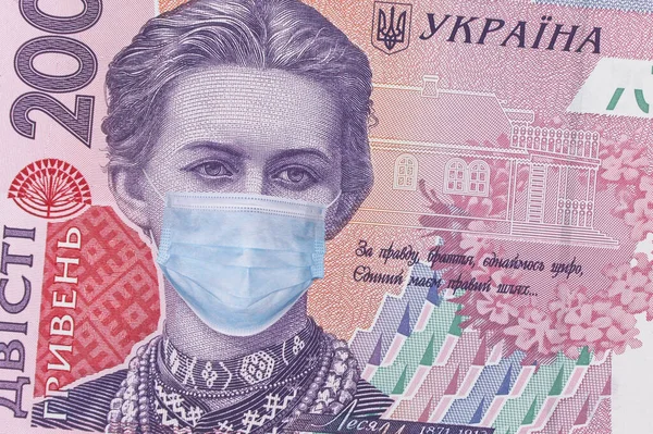 Ukrayna 'da COVID-19 koronavirüsü. 200 Hryvnia banknotu, Lesya Ukrayna 'nın sağlık maskeli hali. Küresel mali ve ekonomik kriz Ukrayna 'yı etkiledi. Ukrayna parası, koronavirüs konsepti, montaj