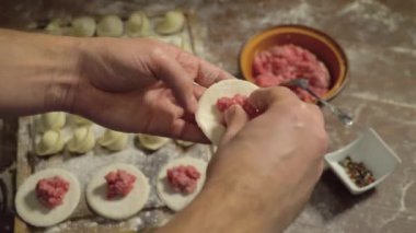 Hamurda köfte, hamur köftesi, yakın plan. Bir parça hamura kıyma ekleyin. Pişirme ve Rus hamur köftelerini yakın plan yapma süreci. Pelmeni ya da etli börek hazırlıyorum..