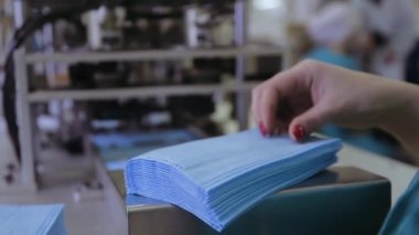 Tıbbi giysi üretimi için fabrikanın atölyesinde tıbbi banttaki maske. Virüse karşı korunmak için tek kullanımlık tıbbi giysi üretimi. Tıbbi maske üretimi.