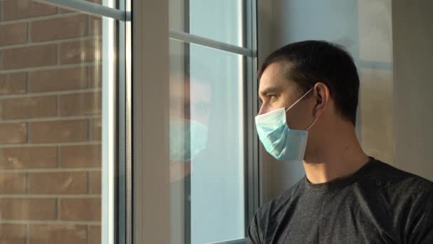 Mannen med medicinsk mask stannar hemma. Självisolering. — Stockvideo