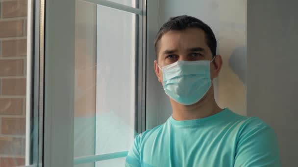Hombre con máscara médica mientras está en casa aislado — Vídeo de stock