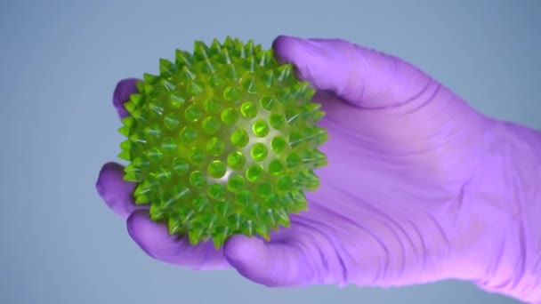 COVID-19, γάντια χέρι κρατά ένα κύτταρο coronavirus — Αρχείο Βίντεο