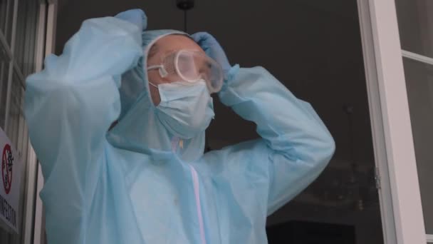 Trabajador con un mono protector inhalando aire fresco — Vídeos de Stock