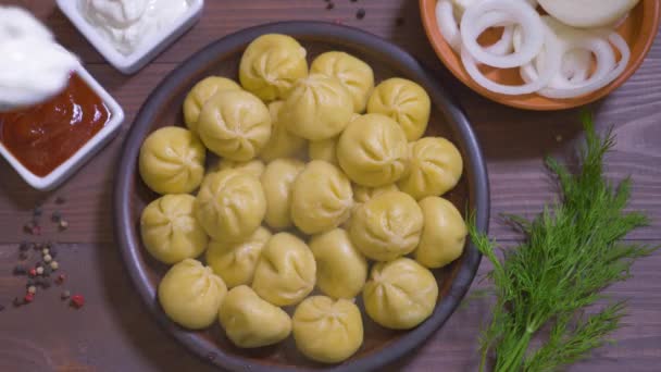 Top view of delicious Khinkali laid on clay plate — Stock Video