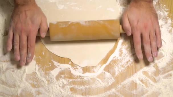 핀을 굴리면서 반죽을 굴려 만드는 요리의 맨 위 사진 — 비디오