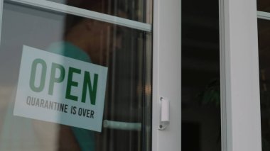 Yansımalı bir vitrinde açık tabela. Kilitleme ve karantinaya son verildi. Kapalı tabela OPEN