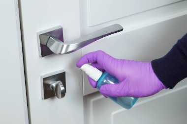 Coronavirus, covid-19 koruması. Bakteri ve virüslerin yüzeylerini dezenfekte etmek, el temizliği kapı kolu ve dezenfektan. Antiseptik sprey ve ıslak mendille kapı kolunu dezenfekte ediyorum. Coronavirüs.