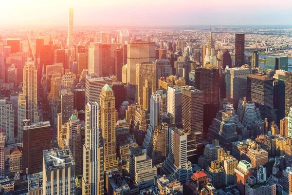 Skyscrapers in New York, aerial view. New York City Manhattan street aerial view with skyscrapers, pedestrian and busy traffic. Sun at sunset.