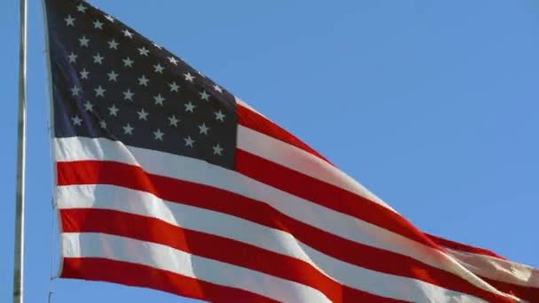 Amerikaanse vlag op een vlaggenmast wapperend in de wind — Stockvideo