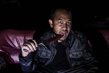 Korkunç bir kanlı bıçak tutan bir adam görüntüsü.