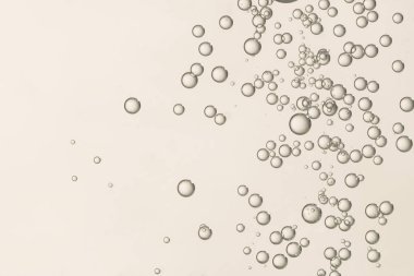 Birçok açık kahverengi gaz baloncukları bulanık bir arkaplan üzerinde izole