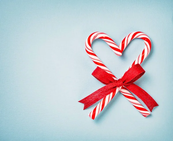 Corazón de bastón de caramelo de Navidad sobre un fondo azul — Foto de Stock
