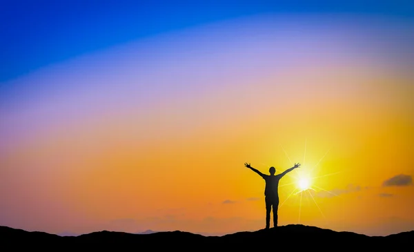 Silhouette di uomo felice in piedi sulla montagna al tramonto . — Foto Stock